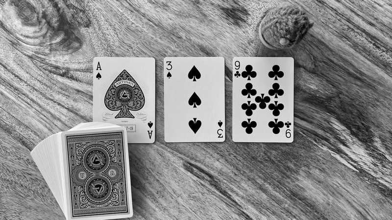 The Ace of Spades, Three of Spades, and Nine of Clubs sit in a neat row above the deck.